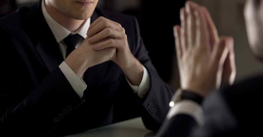 A man sitting across from another man talking