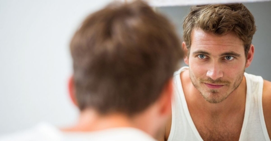 man looking at himself in the mirror