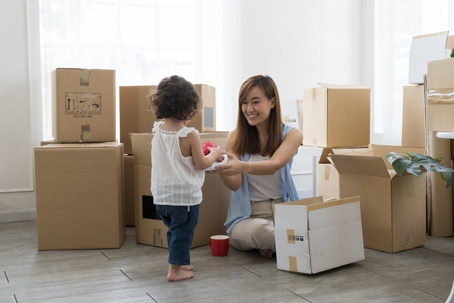 mother and daughter packing moving boxes