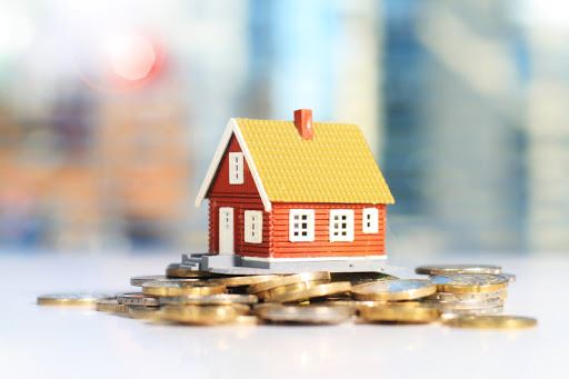 mini house sitting on coins