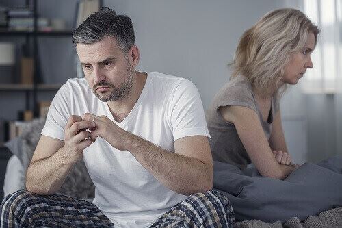 A couple facing away from each other -- both look sad and frustrated with each other. They may be considering filing for divorce.